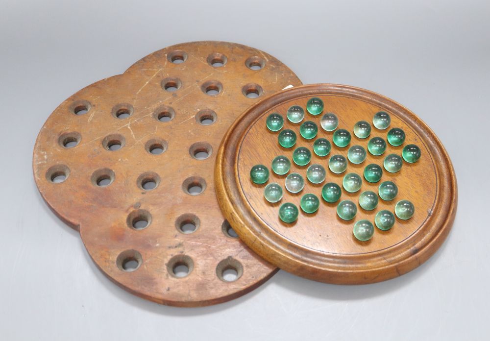 A solitaire board and another without marbles